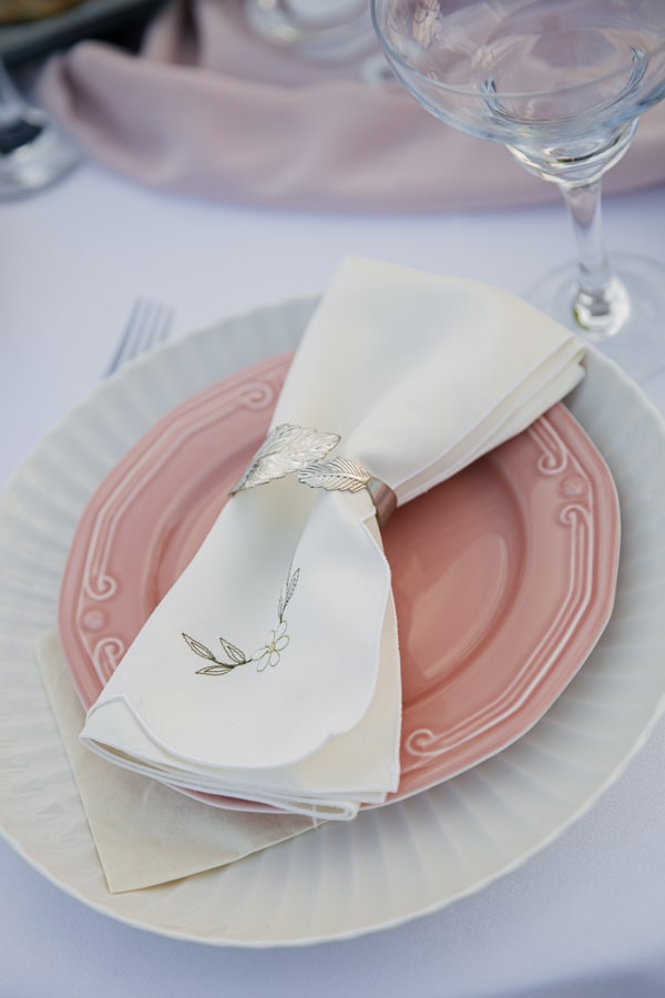 Pink plates and folded napkins at the table