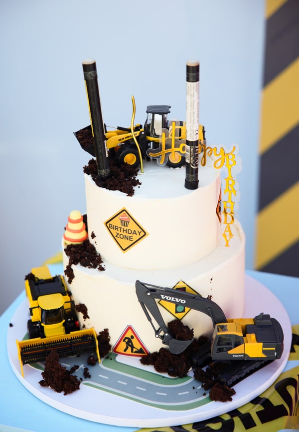 A birthday cake decorated with miniature construction vehicles