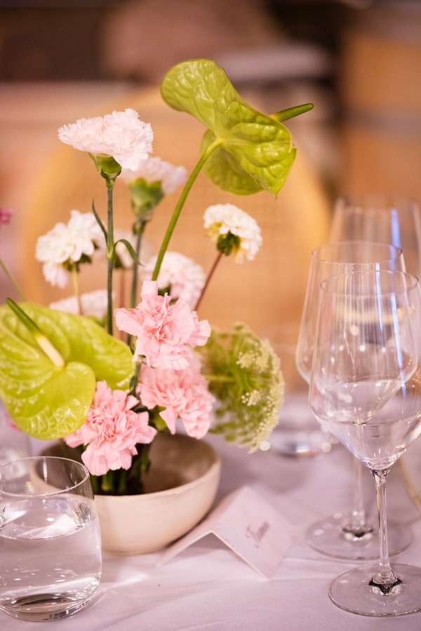 A pale pink table setting with flowers and fruit