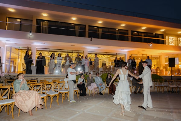 The couple dancing beside the warmly lit winery and reception tables