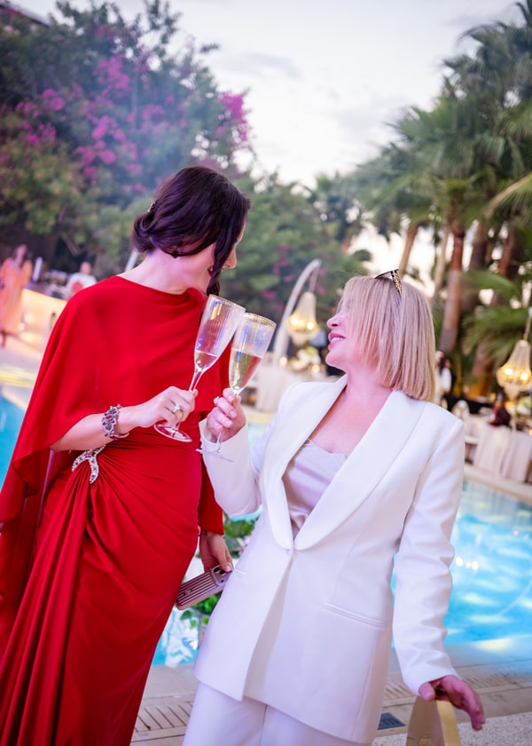 Guests in evening dresses enjoying the poolside celebration