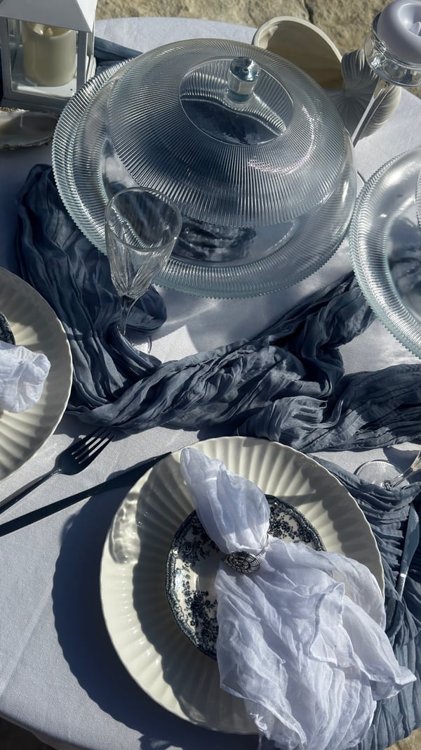 Blue fabric, plates and glassware on a picnic table