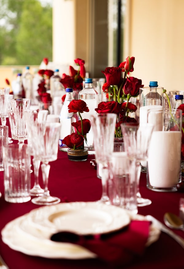 Red flowers, glassware and candles on the birthday table