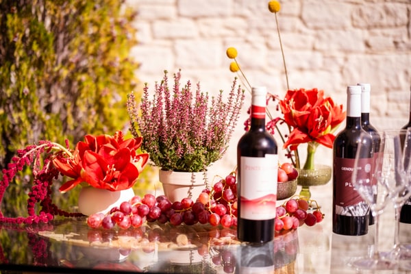 Glasses, bottles and grapes arranged at the bar