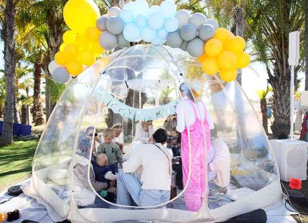 A clear dome with balloons at the outdoor birthday party