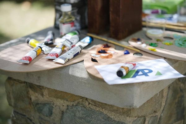 Paints, brushes and palettes on an outdoor table