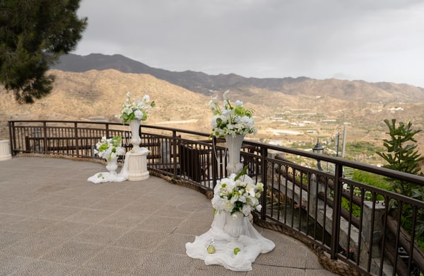 White flowers and flowing fabric arranged on a terrace above the hills