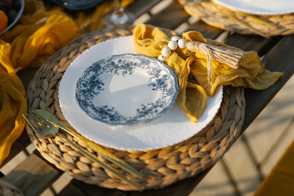 Blue-and-white plates, yellow accents and fruit on a seaside picnic table