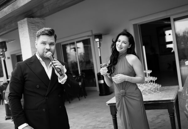 The host speaking into a microphone at the birthday celebration