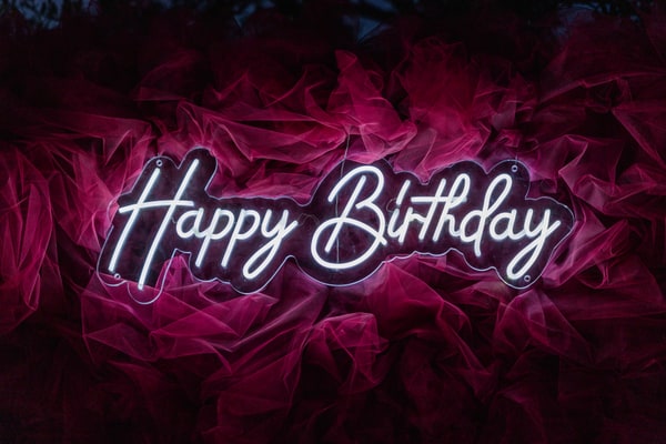 Happy Birthday lettering on a red floral backdrop