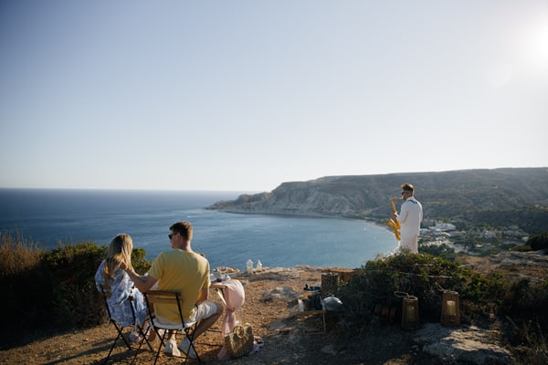 A couple enjoying live saxophone music above the sea