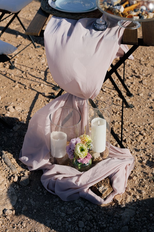 A seaside table with pale pink fabric and white place settings