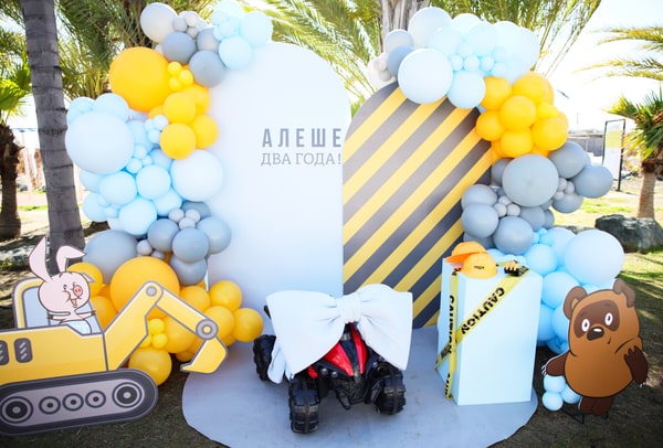 Blue and yellow balloons around a construction-themed birthday display