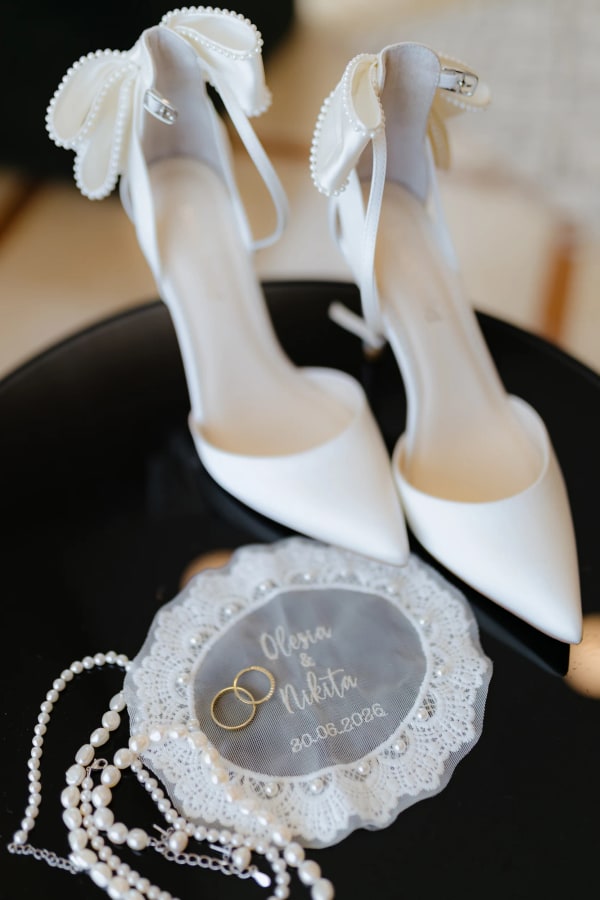 White bridal shoes, pearl jewellery and a personalised shell-shaped ring dish