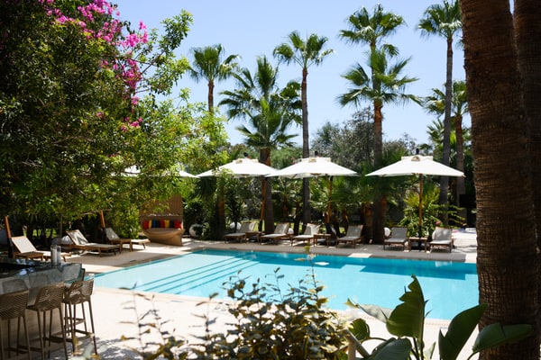 A garden venue with a pool, shaded seating and elegant interiors