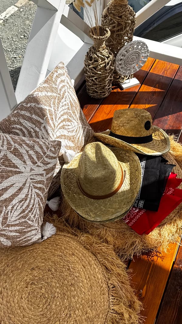 Ranch-inspired cushions, dried grasses and hats on a wooden terrace